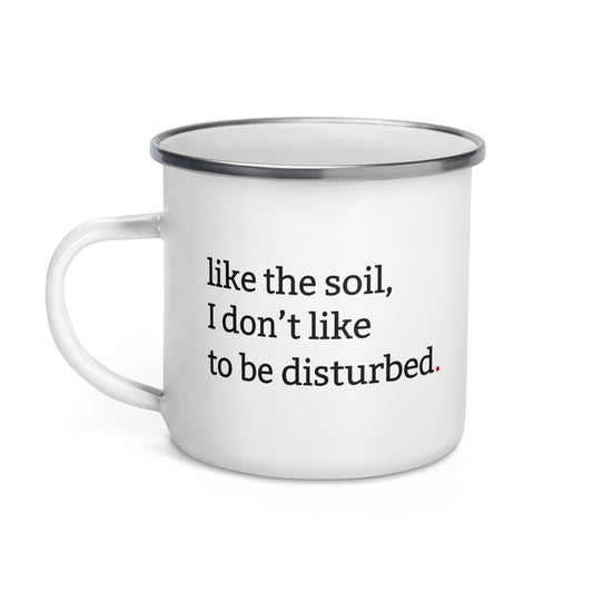 White enamel mug with black rim featuring “Like the soil I don’t like to be disturbed” and “Tolerance is seasonal” text