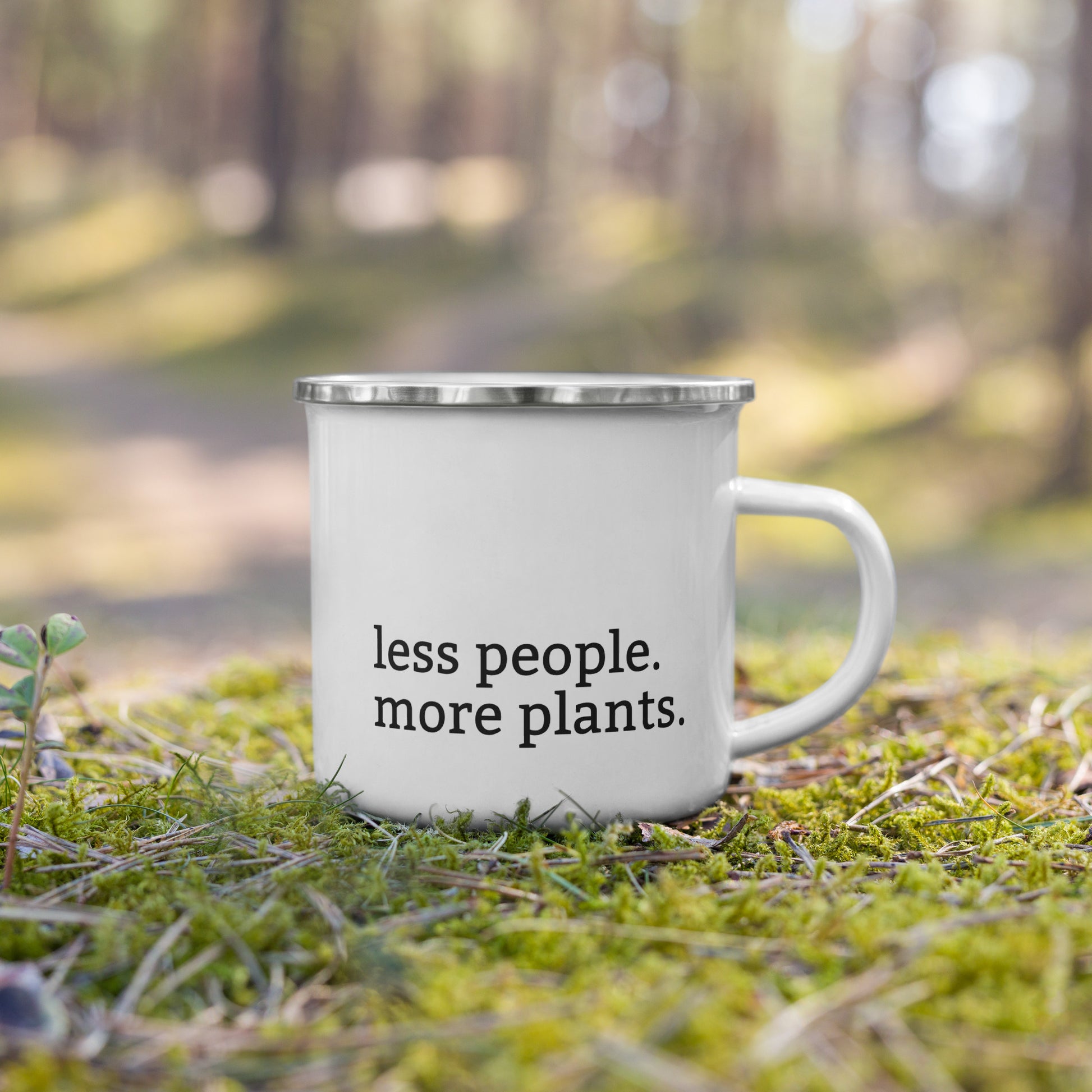 White enamel mug with black rim featuring “Peace in the dirt” and “Less people, more plants” text


