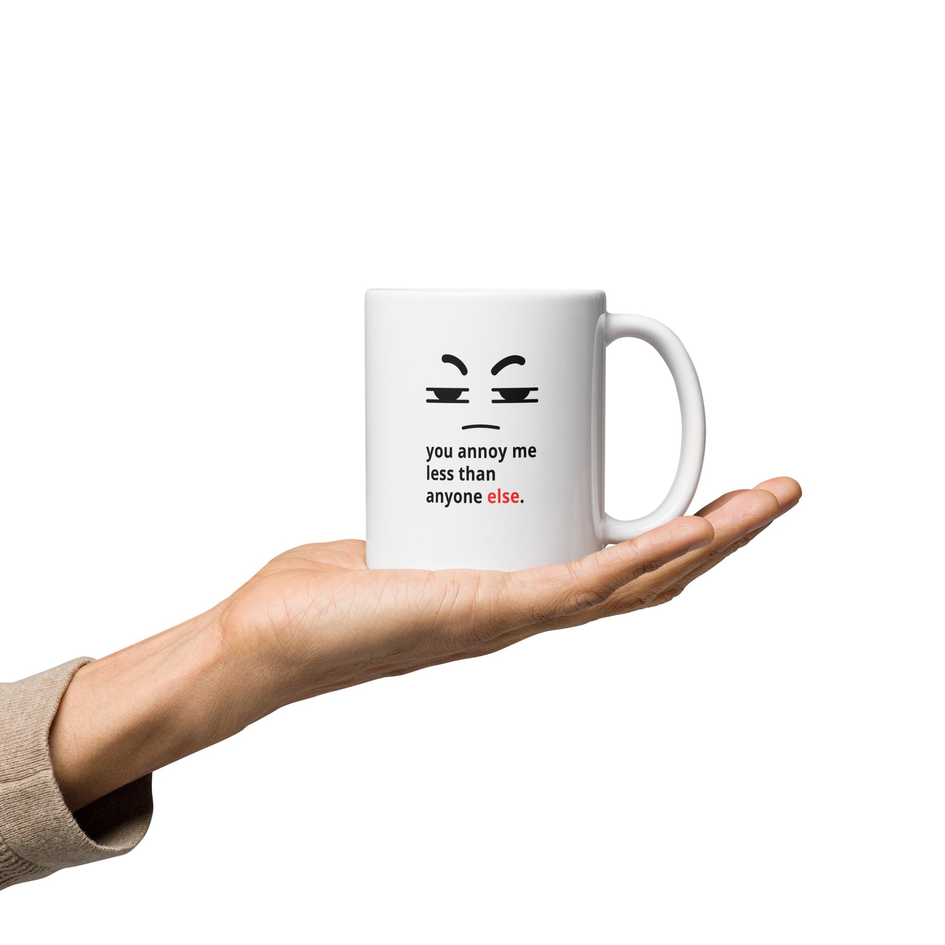 Snarky relationship mug with “You Annoy Me Less Than Anyone Else” text and frowning face design on hand 